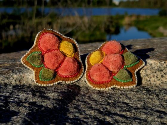Inspired by the vibrant colours that blanket the northern tundra each summer, these earrings celebrate the beauty that flourishes in a landscape shaped by resilience. Created using traditional caribou hair tufting on hand-tanned and smoked moosehide, they honour the knowledge, artistry, and respect for the land that have been carried forward through generations. Through every stitch and tuft, this piece reflects the enduring relationship between people, culture, and the North.