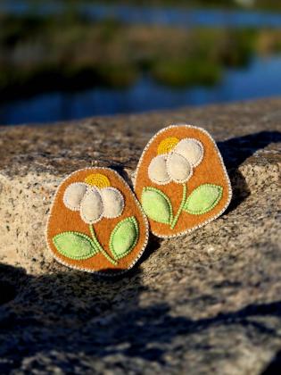 Inspired by the cottongrass that sways across the northern tundra, these earrings celebrate the quiet beauty found in the simplest moments on the land. Handcrafted using traditional caribou hair tufting on hand-tanned and smoked moosehide, they honour the artistry, knowledge, and respect for the land that have been carried forward through generations. Through every stitch and tuft, this piece reflects the enduring connection between people, culture, and the North.
