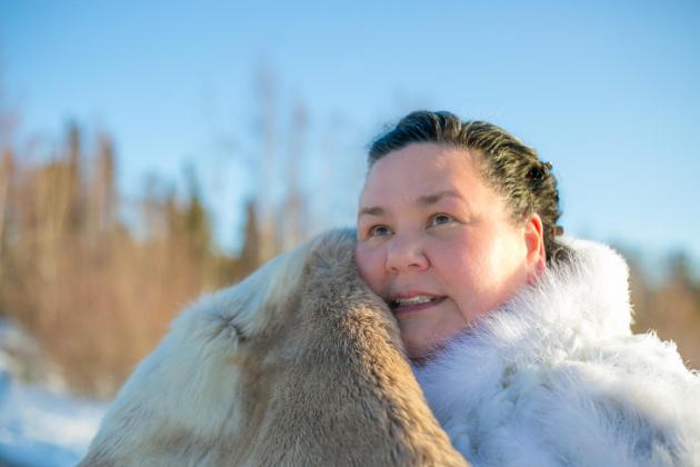 Inuk, holding a caribou hide
